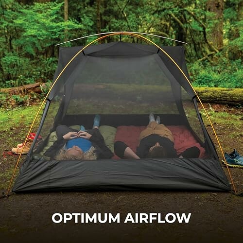 Two people relaxing inside a mesh camping tent in a forest.