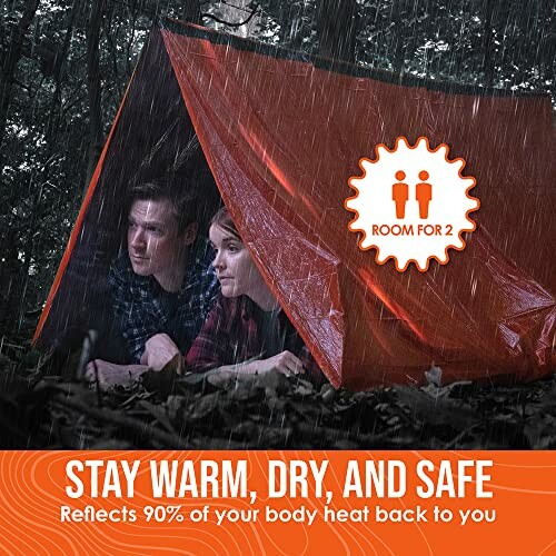 Two people under an orange emergency tent in the rain.