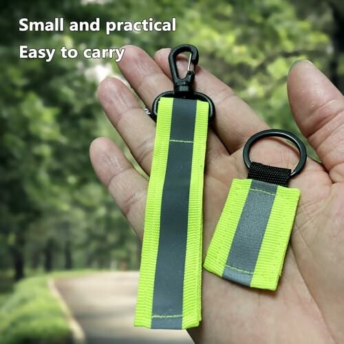 Hand holding small reflective keychains, easy to carry.