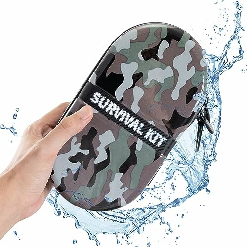 Hand holding a waterproof camo survival kit case with water splashing